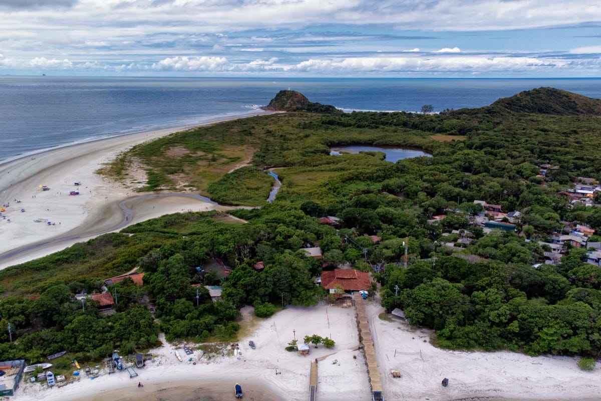Vista aérea da Ilha do Mel, com praia, vegetação de restinga e trapiche