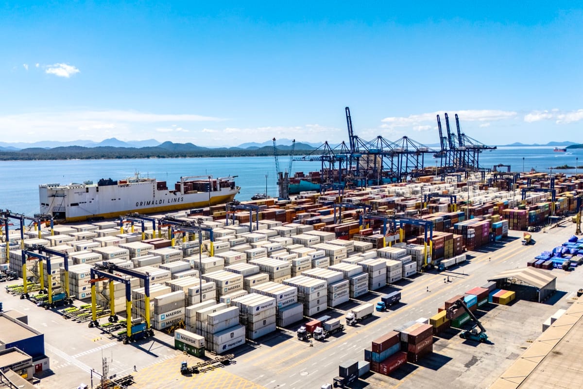 Vista aérea do terminal de contêineres de Paranaguá, com pilhas de contêineres refrigerados e um navio atracado